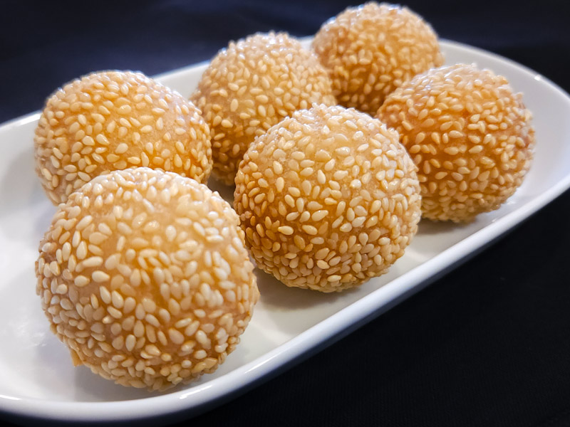 6 piece serving of Fried Crispy-Outside Chewy-Inside Sesame-coated Rice Balls with sweet Red Bean paste filling. Sesame Balls(6Pc)