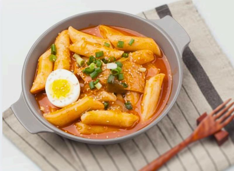 Chewy Korean rice cakes cooked in sweet and spicy gochujang sauce with fish cake, cabbage, and green onion Tteokbokki
