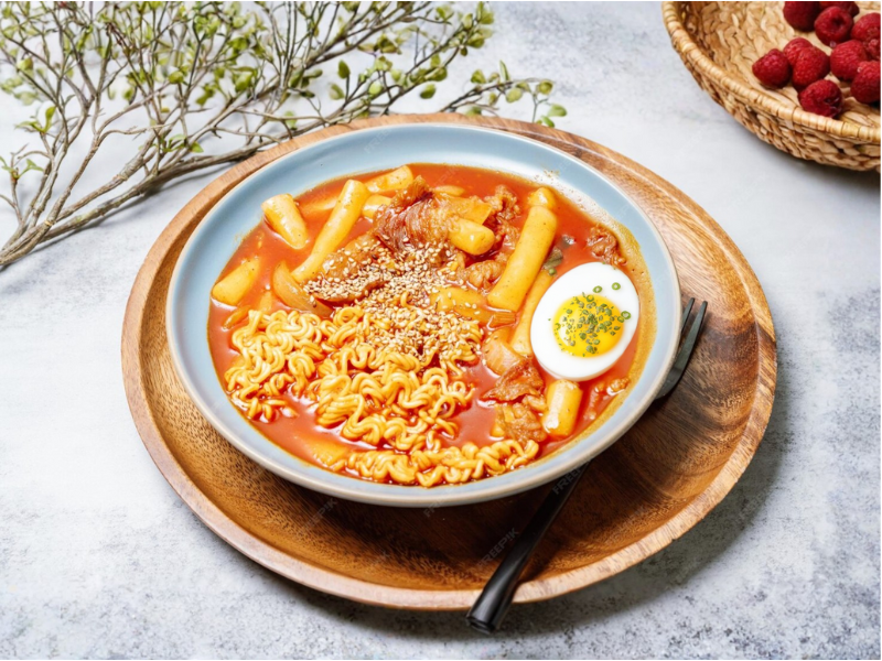 Chewy Korean rice cakes cooked in sweet and spicy gochujang sauce with fish cake, cabbage, and green onion Rabokki