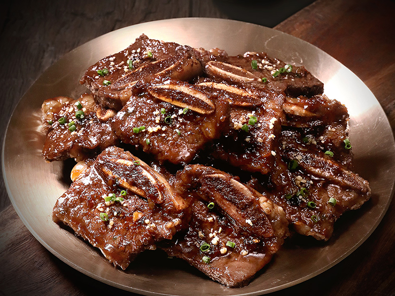 Grilled beef short ribs marinated in a sweet and savory Korean BBQ sauce for a tender, smoky flavor.  La Galbi