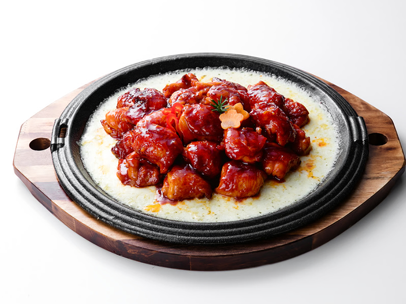 Spicy boneless chicken, topped with melted cheese, rice cake and on a bed of onions Cheese Buldak