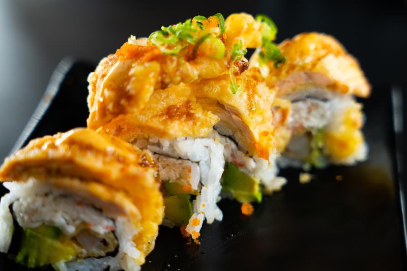 In: Shrimp tempura, krabmeat, avocado | Out: Salmon tempura | Top: Ponzu, sp. mayo, eel sauce, masago, green onion Salmon Tempura