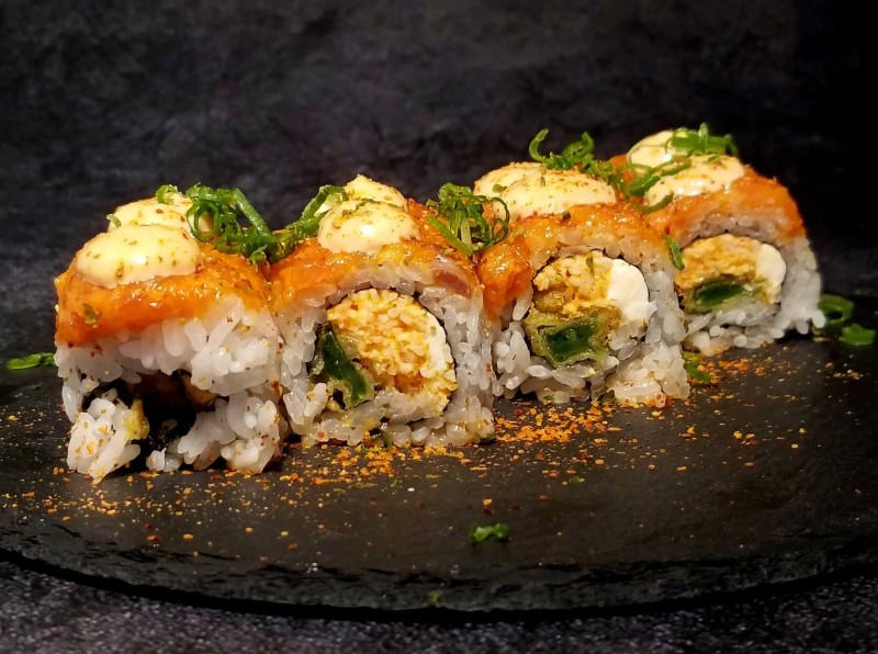 Spicy Crab, Cream Cheese, Tempura Green Onion inside. Spicy Salmon, Extra Spicy Mayo and Ponzu Sauce on top. Tsunami Roll