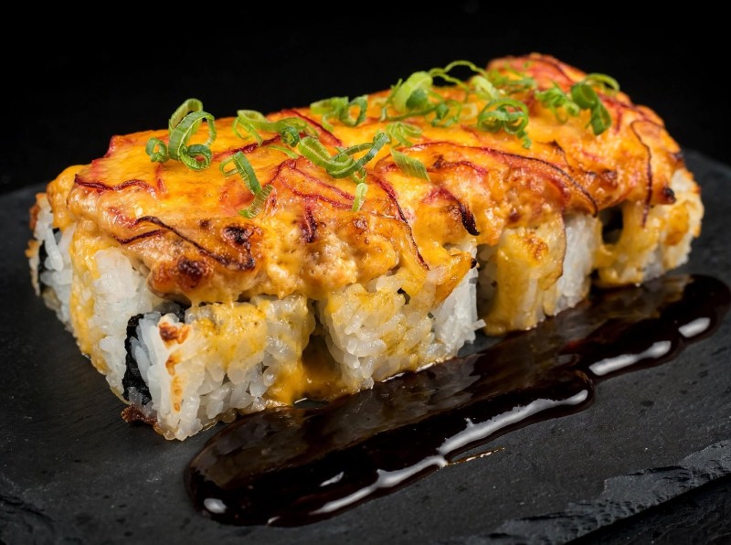 Crab Mix, Avocado inside. Spicy Salmon, Red Onion, Spicy Mayo on top and Baked. Eel Sauce, Green Onion on top. Lion King Roll