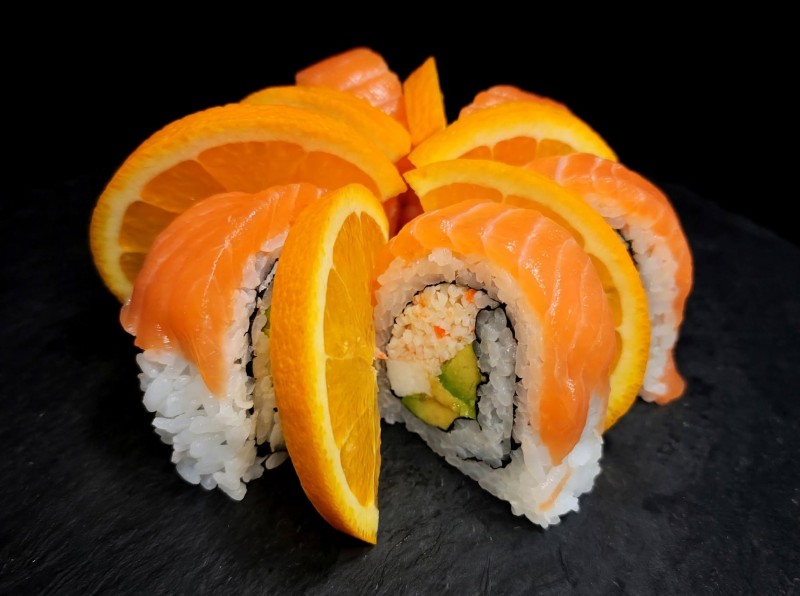 Spicy Crab Mix, Cream Cheese, Cucumber, Avocado Inside. Salmon, Real Wasabi, Red Onion on Top. Orange Blossom Roll