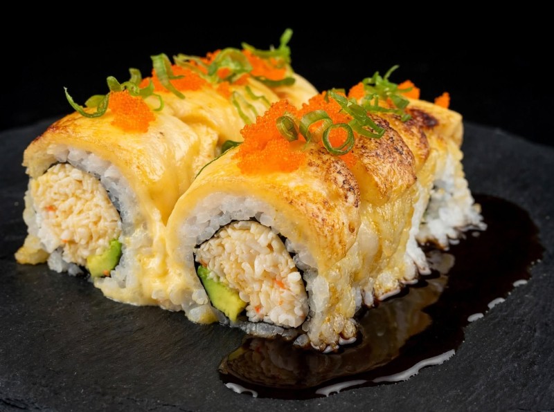Spicy Crab Mix, Avocado inside. White Tuna, Spicy Mayo on top. Bake. Masago, Green Onion, Eel Sauce on top. Sun's Roll